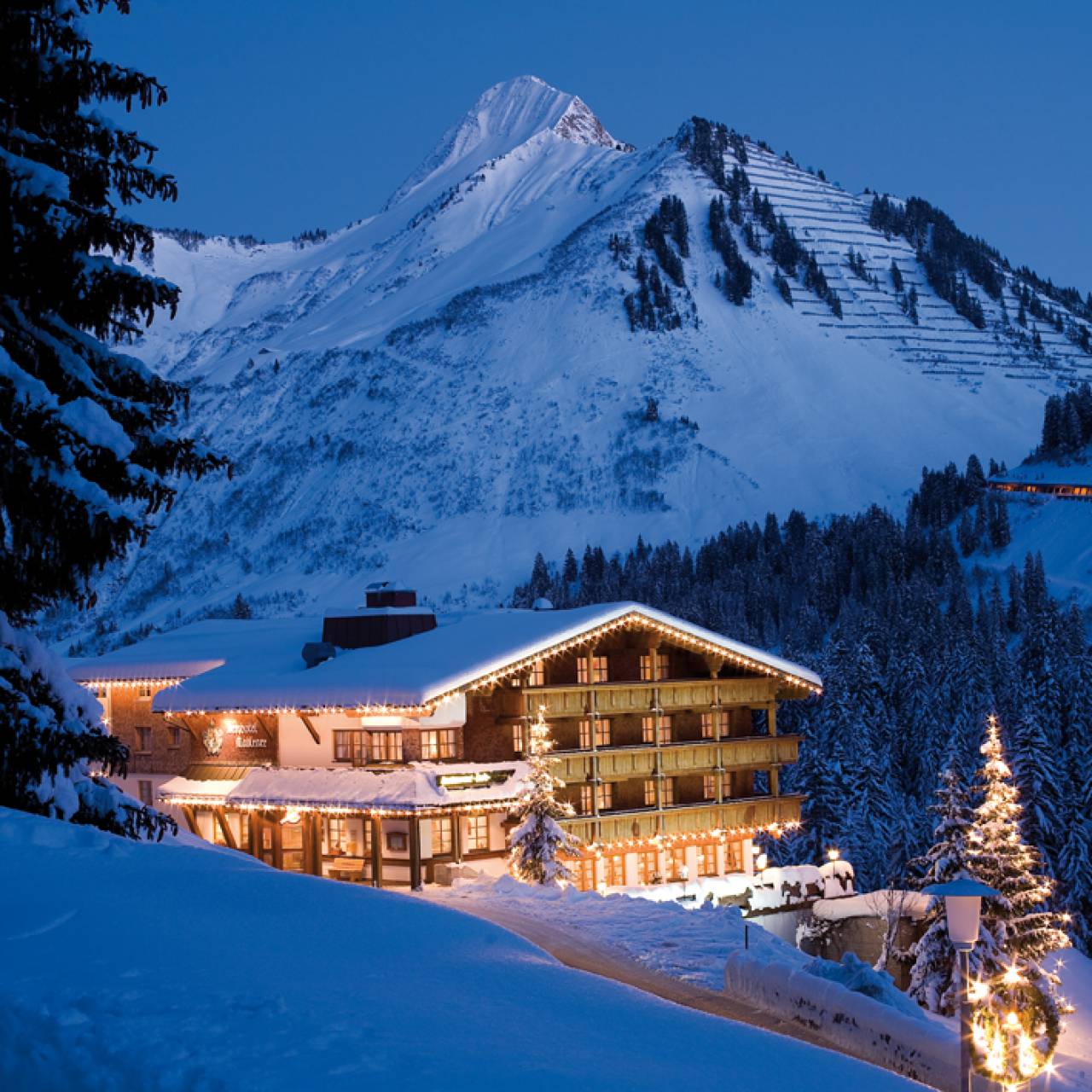 Berghotel Madlener in den verschneiten Alpen bei Nacht in Damüls